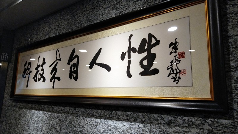 佐臻門口擺了「科技來自人性」的書法，這也是梁文隆給自己的目標。（攝影／籃貫銘）