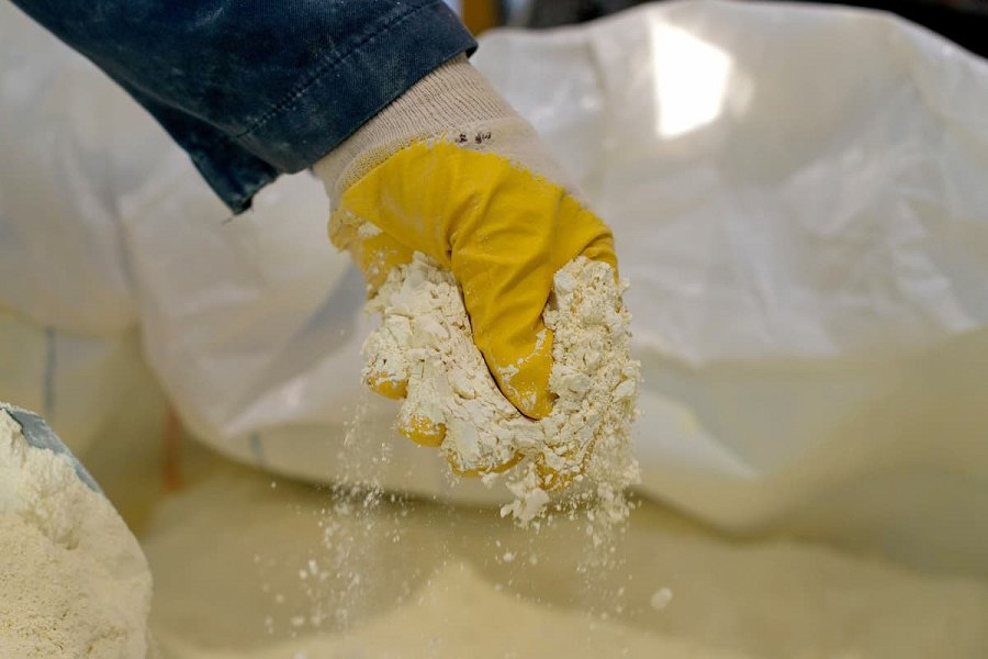 ：愛沙尼亞的Silmet工廠，一名工人展示分離過程中的稀土氧化物。（source：AXION）